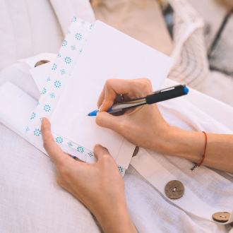 a person is signing a postcard